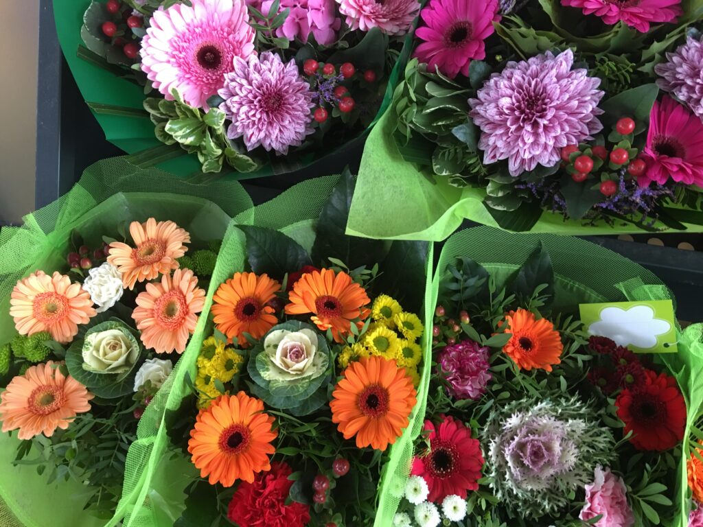 葉ボタン、ガーベラ、カーネーション、ヒペリカム、スプレーマム、ディスバッドマムで作られた花束
